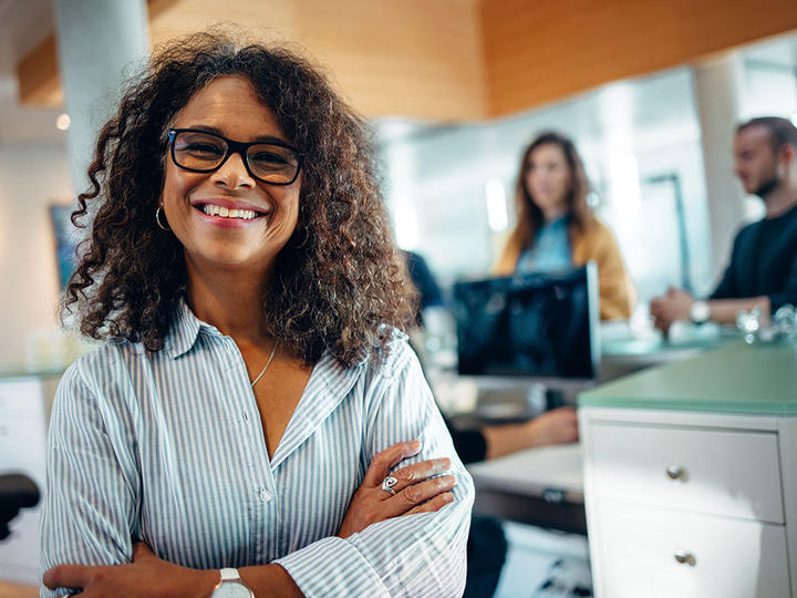 A woman smiling with people in the background