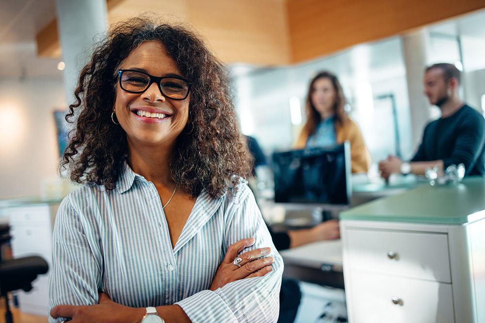 A woman smiling with people in the background