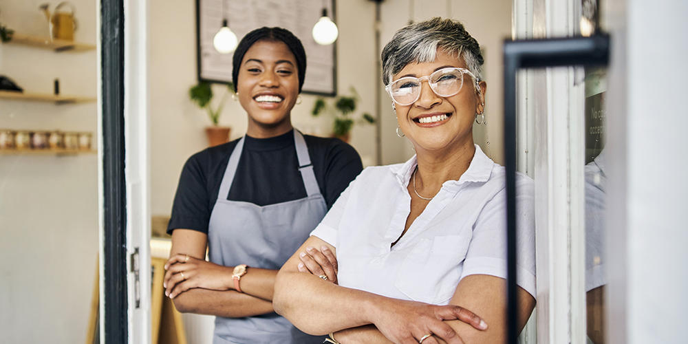two women wearing aprons in a restaurant window